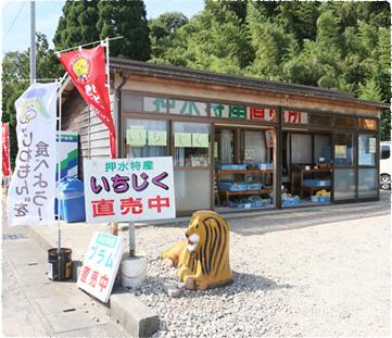 押水特産直売所の小屋の前に看板や動物のオブジェが置かれている写真