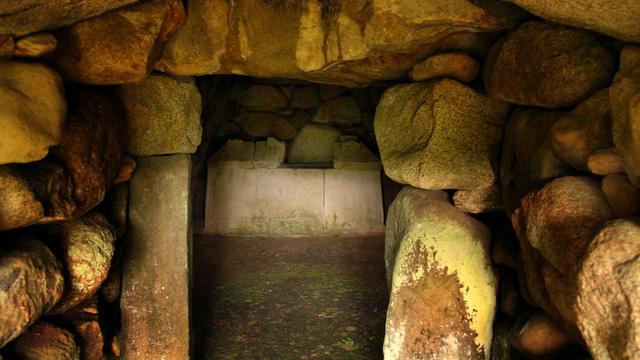 石が積まれた部屋の奥に、石の棺が見えている写真