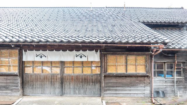 暖簾がかかった出入り口を瓦屋根と一緒に写した写真