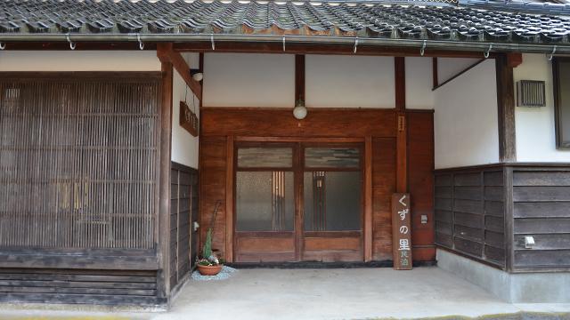 和風建築の玄関に、くずの里民泊の看板が置いてある写真