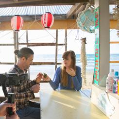 海を背景に海の家で楽しそうにしている2人の写真