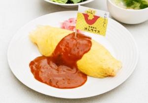 皿に盛られたオムライスにソースがかけられその上に旗が立っている写真