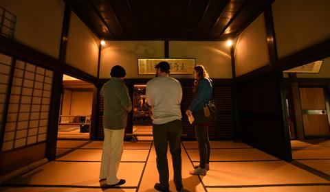 和室の中で立ちながら話をしている3人の写真