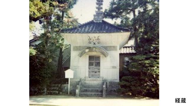 白い壁に青い屋根をした経蔵の写真