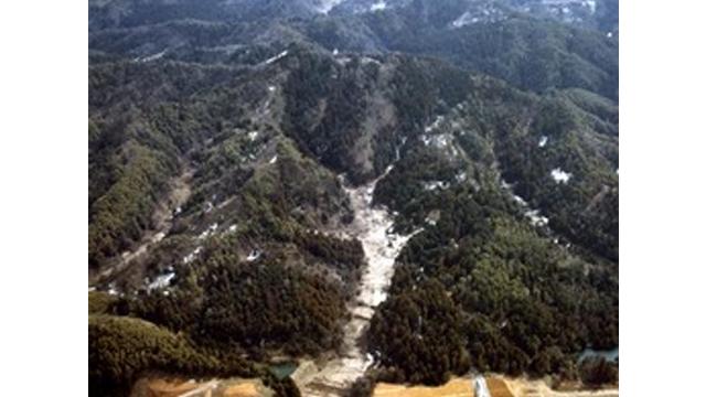 木々に覆われた山々の間に、白い地面の谷間が見えている写真