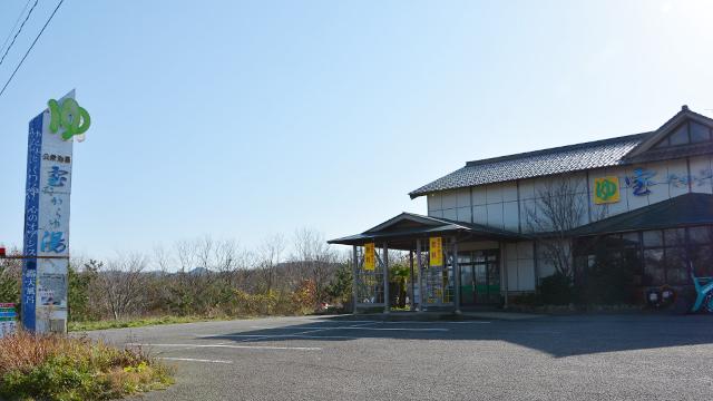 駐車場をはさんで、宝湯の看板と建物が建っている写真