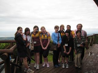 宝達山の山頂で一面の曇り空をバックに記念撮影をするオーストラリアのヌーサから来日した研修生たちと関係者らの写真