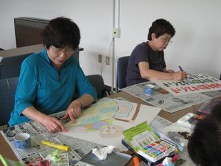 平成21年7月23日に二人の女性が紙芝居を作成している様子を撮った写真