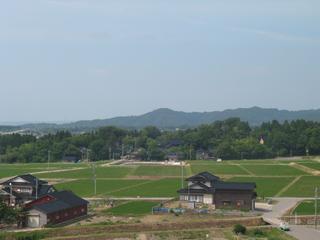 山を背景に末森城跡を遠景から撮った写真