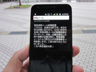 緊急速報メールの見本を映し出したスマートフォン画面の写真