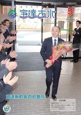 職員に拍手で迎えられ緊張気味の笑顔を浮かべて両手で花束を持つ寶達町長の初登庁の写真を全面に載せた広報宝達志水の平成29年5月号の表紙