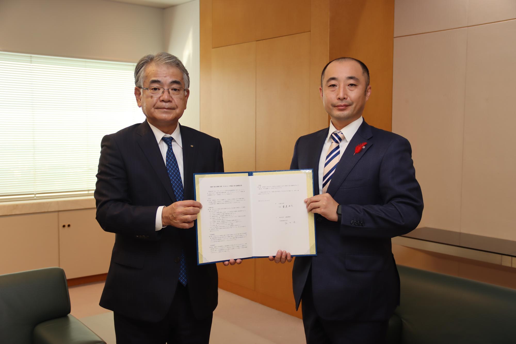 協定書に署名した株式会社北國新聞社の温井社長（左）と寳達町長