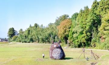 森を背にした広場に、キャラクターの大きなオブジェが置かれている写真