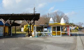 屋根にソフトクリームの模型が二つ乗っている、黄色い小屋の外観の写真