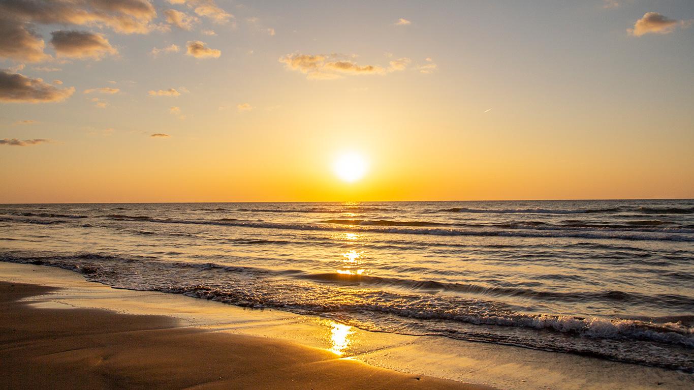 砂浜から撮影した夕暮れの波打ち際の写真