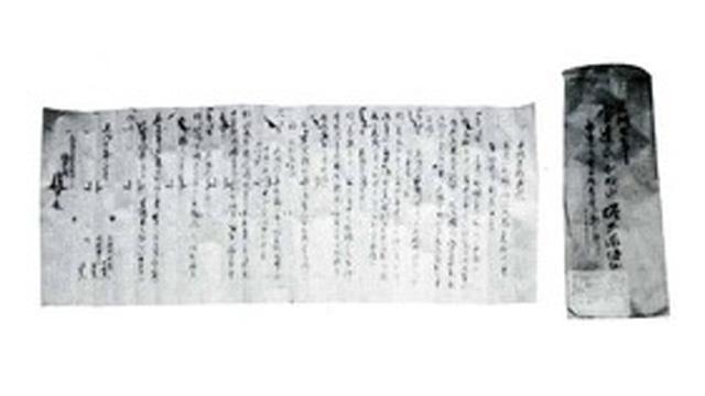 縦書きで書かれた横長の文書の横に、縦長の文書が置かれている写真