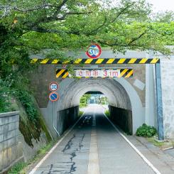 山の道路に設置されたトンネルの写真