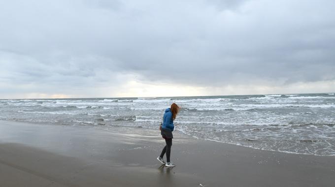波打ち際で歩いている女性の写真