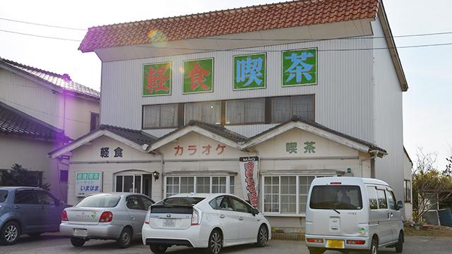 壁に軽食喫茶と書かれている、一戸建ての喫茶店の外観の写真