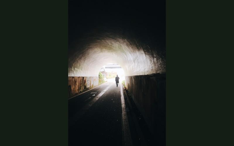 トンネル内から出口に向かっている人の写真