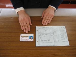 机の上に運転免許証と書類が並べられ上から撮影している写真